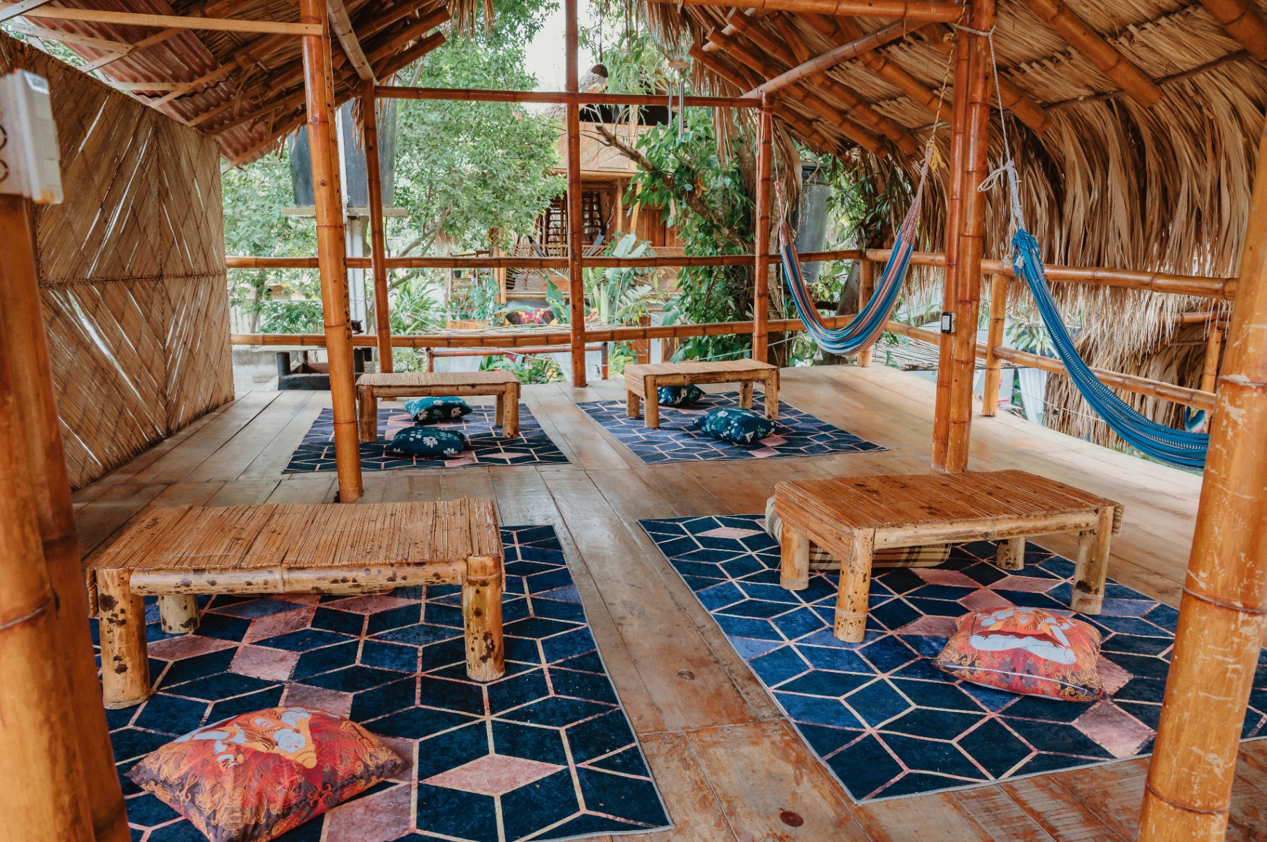Sala maloka con hamacas y mesas bajas