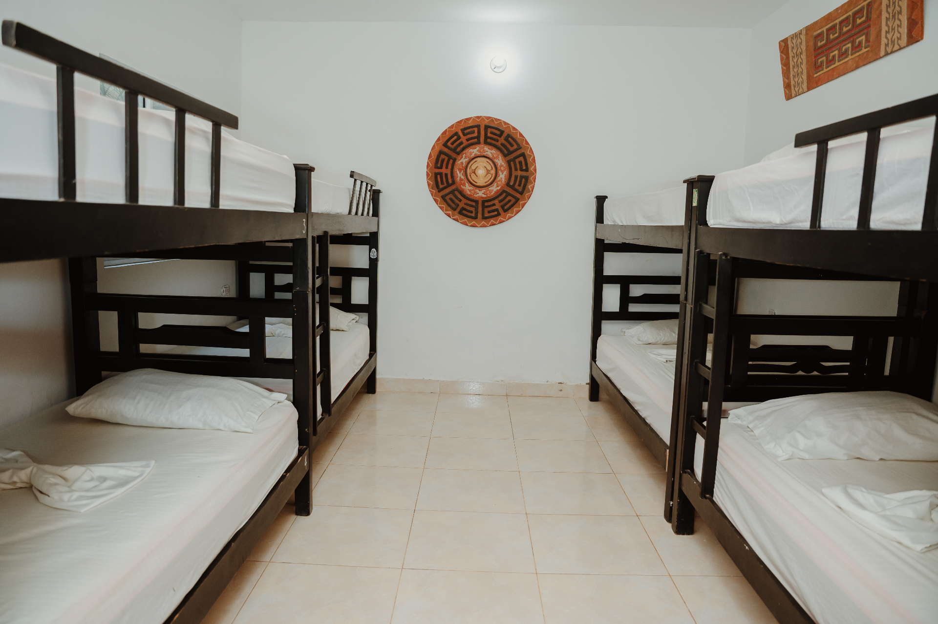 Dormitorio WAYU - vista general con literas y arte indígena