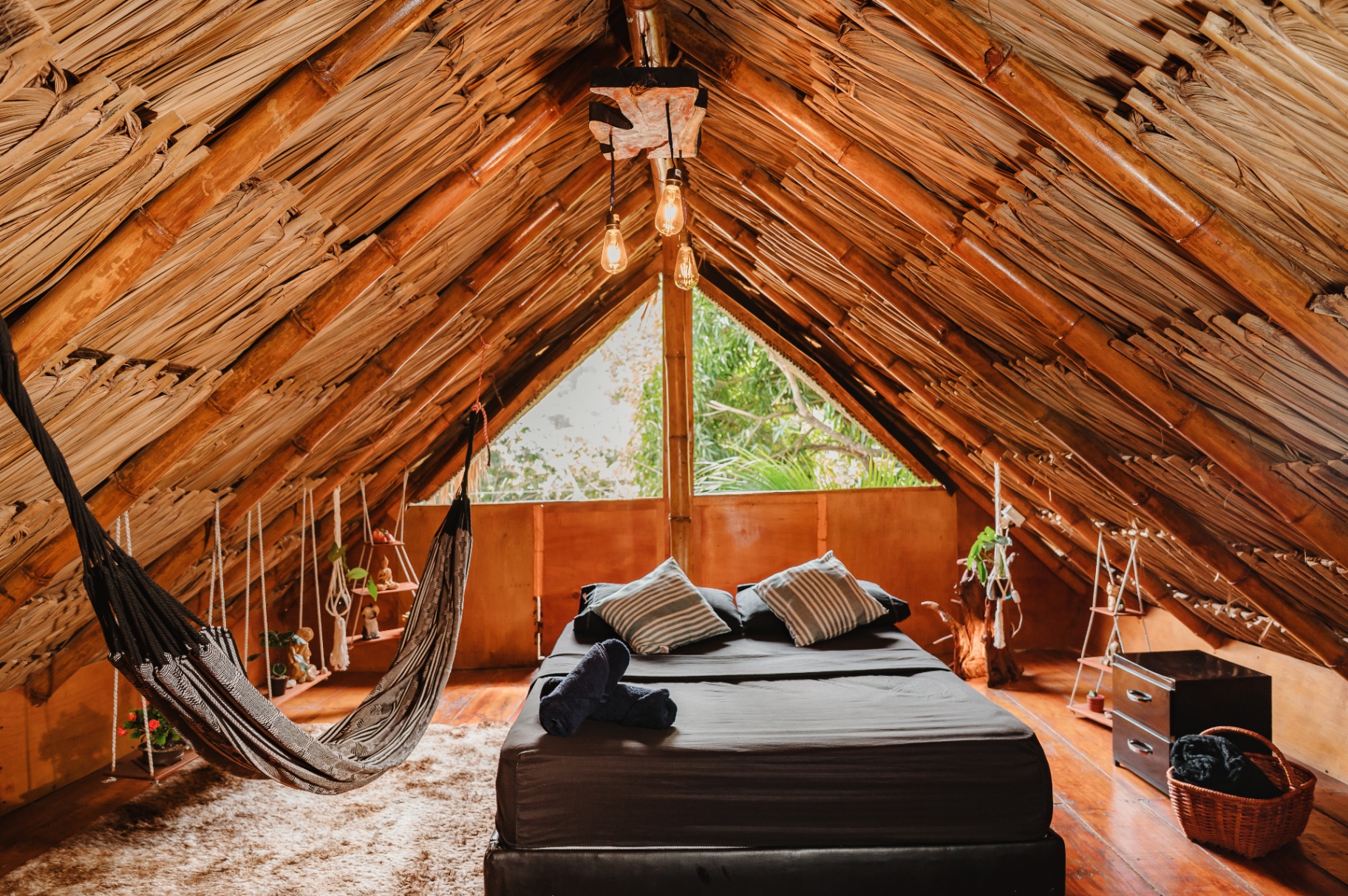 Habitación KOGUI - loft con techo de palma, cama y hamaca